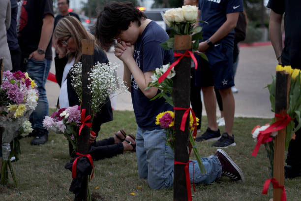 ALLEN, TEXAS - MAY 07: Carson Smith prays at a memorial next to the Allen Premium Outlets on May 7, 2023 in Allen, Texas. The memorial is for the victims of the mass shooting in the Allen Premium Outlets mall on May 6th. According to reports, a shooter opened fire at the outlet mall, killing eight people. The gunman was then killed by an Allen Police officer that was responding to an unrelated call. (Photo by Joe Raedle/Getty Images) 박영대 기자 sannae@donga.com