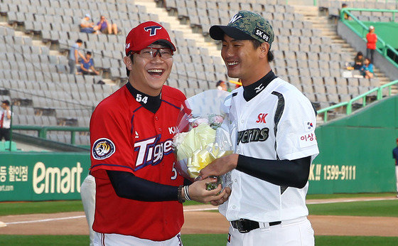 21일 오후 인천 SK행복드림구장에서 열리는 ‘2015 타이어뱅크 KBO 리그’ SK 와이번스와 KIA 타이거즈의 경기 시작전 양현종이 ‘김광현 1,000탈삼진 달성 시상식’에서 김광현에게 꽃다발을 건내고 있다. (SK 와이번스 제공) 2015.9.21/뉴스1