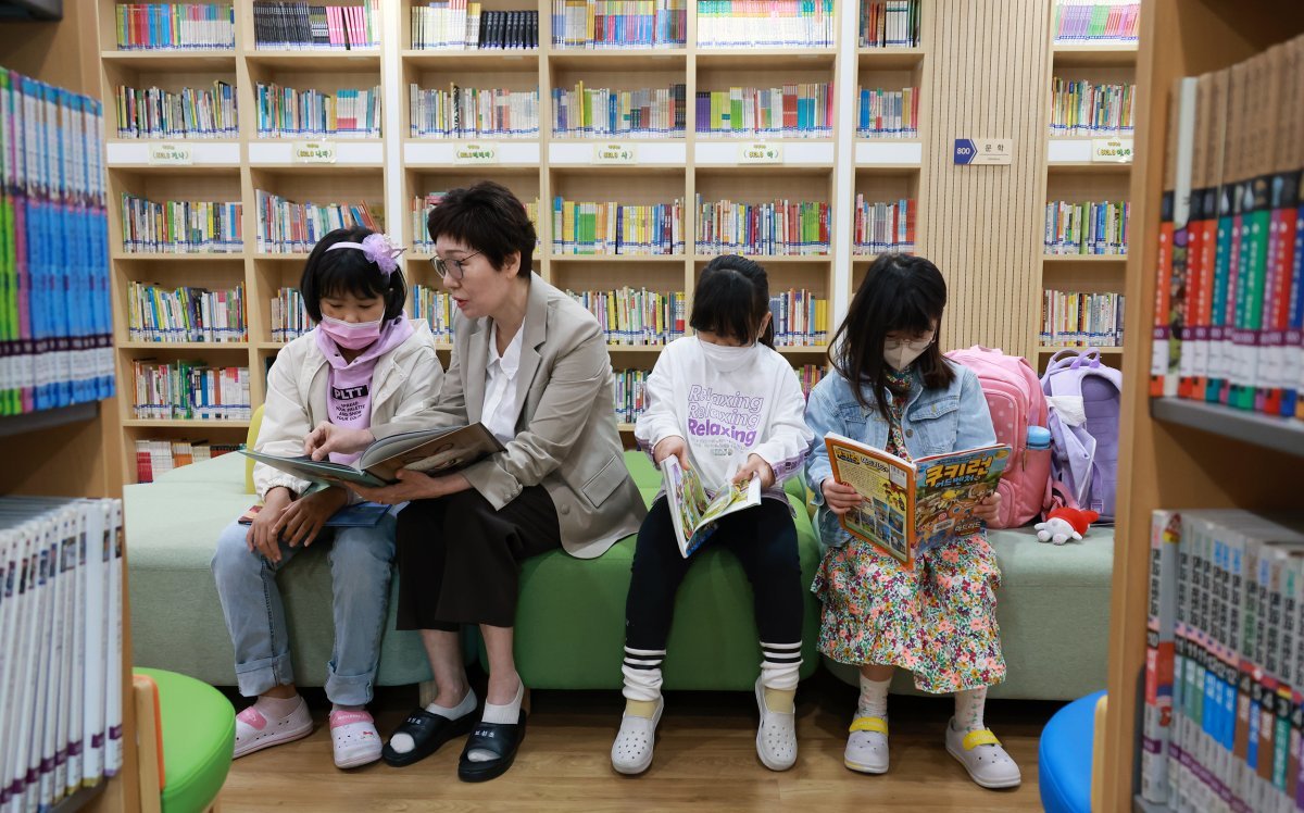 2일 대전 중구 보성초에서 김시명 양, 돌봄 전담사 이은순 씨, 김설 양, 신소헌 양(왼쪽부터)이 도서실에 모여 책을 읽고 있다.
 3월 늘봄교실 시범학교로 선정된 보성초는 1, 2학년 수업 시간인 오전 9시보다 1시간 반 이른 7시 반부터 도서실을 개방해 
아이들을 돌보고 있다. 교육부 제공