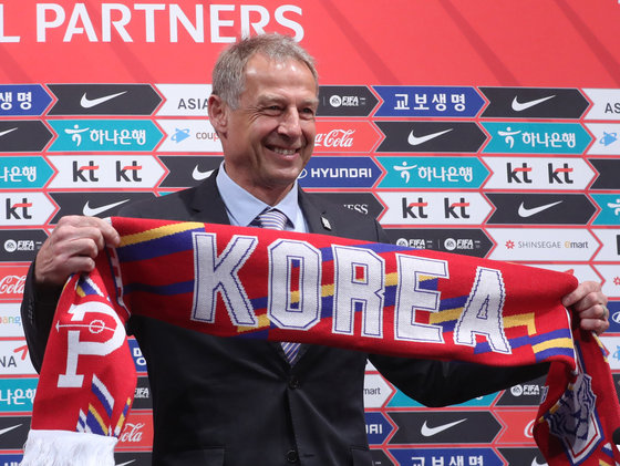 위르겐 클린스만 신임 한국 남자 축구국가대표팀 감독이 9일 경기 파주 축가대표팀 트레이닝센터(NFC)에서 취임 기자회견에서 머플러를 들고 기념촬영을 하고 있다. 2023.3.9 뉴스1