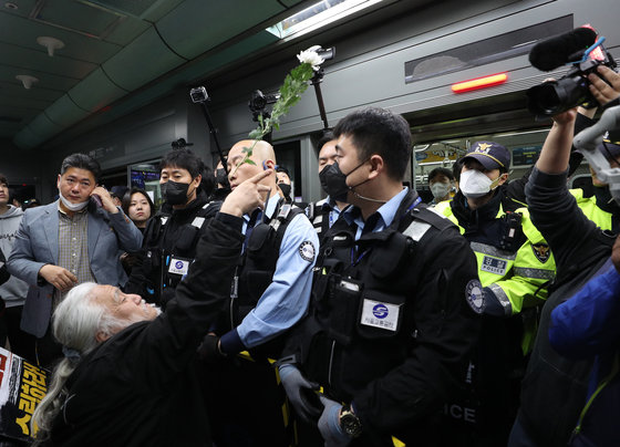 박경석 전국장애인차별철폐연대(전장연) 상임공동대표가 21일 오전 서울 광화문역에서 지하철 탑승 시위를 하며 열차를 향해 국화꽃을 던지고 있다. 2023.4.21/뉴스1