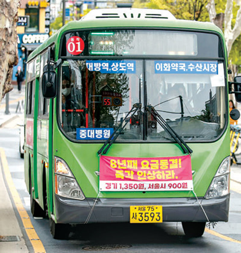 지난달 서울시내를 운행 중인 마을버스에 "8년째 요금동결! 즉각 인상하라"라고 쓰인 현수막이 붙어있다. 뉴시스