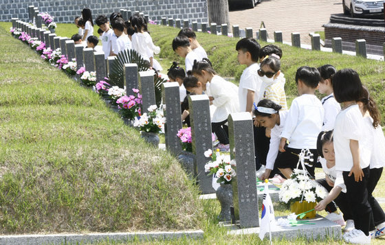 5.18민주화운동 43주년을 앞둔 16일 광주 북구 국립 5.18민주묘지를 찾은 아이들이 헌화하고 있다. 2023.5.16/뉴스1