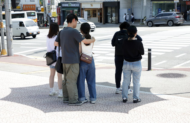 17일 오전 울산대학교 앞 신호등 대기 공간에 마련된 파라솔 아래서 대학생들이 햇빝을 피하고 있다.2023.5.17. 뉴스1