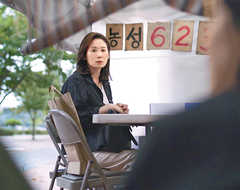 영화 ‘드림팰리스’에서 혜정(김선영)이 죽은 남편이 일하던 회사 앞에서 함께 농성했던 유가족들을 바라보고 있다. ㈜인디스토리 제공