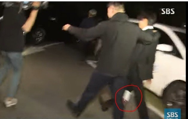 유아인이 24일 밤 구속영장 기각 소식을 받은 뒤 귀가하기 위해 자신의 차량으로 돌아가던 순간, 한 시민이 던진 페트병 커피(붉은 원)에 아랫도리를 맞았다. (SBS 갈무리) ⓒ 뉴스1