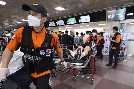 26일 오전 제주공항을 출발해 대구공항으로 향하던 아시아나 항공기에서 비행 중 문이 열리는 사고가 발생했다. 울산에서 열리는 제52회 전국소년체육대회에 참가하기 위해 비행기에 탑승했던 초·중학생 제주특별자치도 선수단 가운데 대구공항 도착 직후 고통을 호소하는 선수들을 119구조대가 들것을 이용해 구급차로 옮기고 있다. 2023.5.26/뉴스1