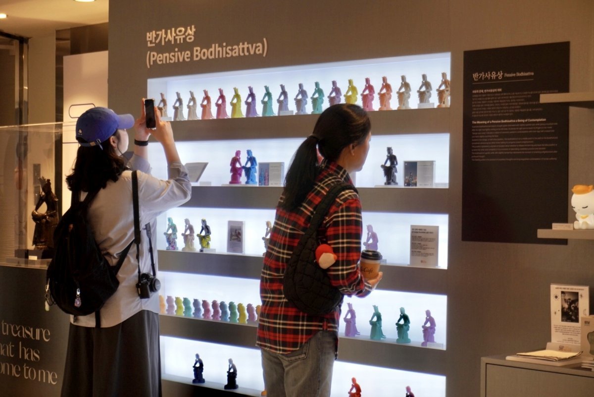 서울 중구 롯데백화점 본점에 마련된 국립박물관문화재단의 팝업스토어에서 젊은 여성 고객들이 진열장에 놓인 반가사유상 미니어처를 둘러보고 있다. 국립박물관문화재단 제공