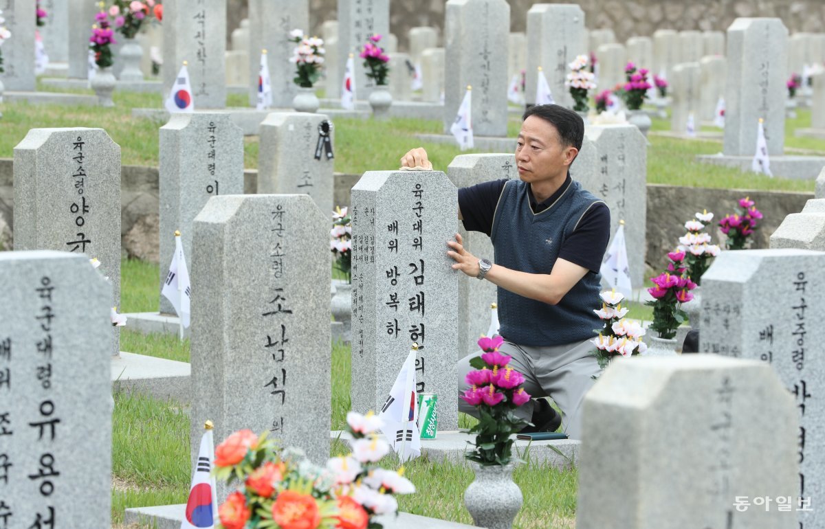 한 유족이 묘비를 닦으며 추모를 하고 있습니다.