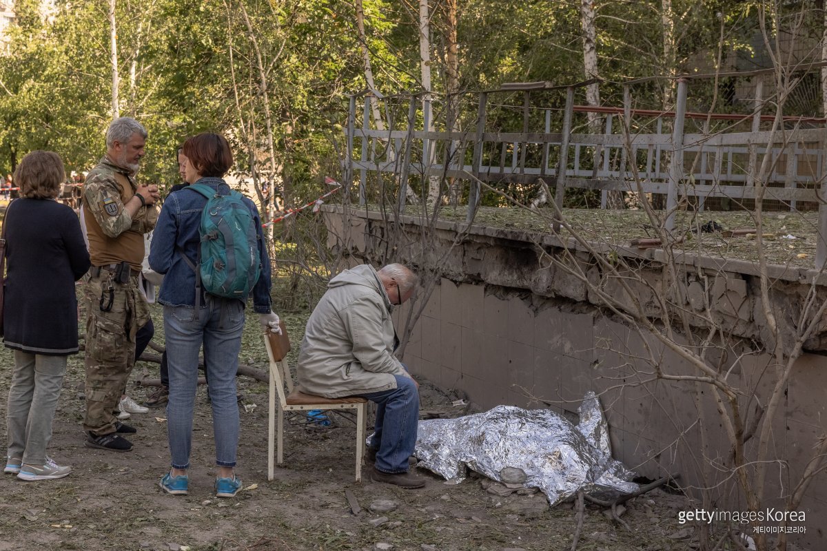 1일(현지시간) 우크라이나 키이우 데스냔스키 지역에서 할아버지가 러시아 미사일 공격으로 사망한 9세 손녀의 시신 옆에 앉아 있다. ⓒ(GettyImages)/코리아