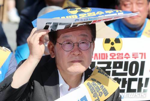 이재명 더불어민주당 대표가 3일 부산 부산진구 서면 쥬디스태화 앞에서 열린 후쿠시마 원전 오염수 해양투기 규탄대회에 참석, 손팻말로 햇빛을 가리고 있다. 뉴시스