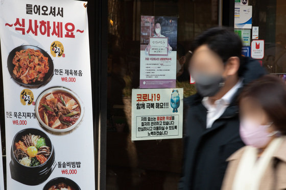서울 명동의 한 식당 입구에 ‘코로나19 극복’ 안내문이 붙어있다. 2022.1.24/뉴스1 ⓒ News1