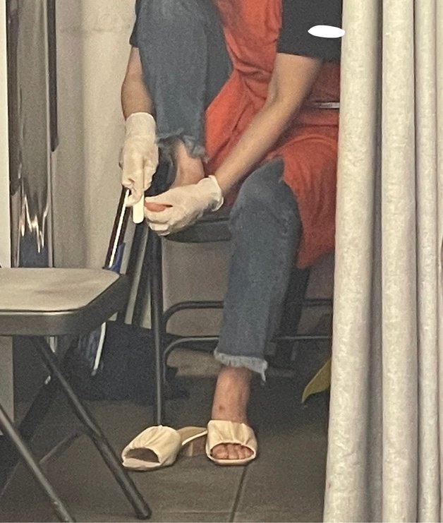 커피 프랜차이즈 ‘더벤티’의 한 매장 직원이 장갑을 낀 채 발 각질을 정리하고 있는 모습. (온라인 커뮤니티 갈무리)