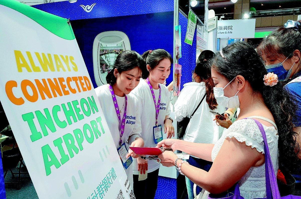 흰색 티셔츠를 입은 인천국제공항공사 직원들이 지난달 27일 대만 타이베이에서 열린 국제관광박람회를 찾은 외국인들에게 인천공항의 여객서비스에 대해 설명하고 있다. 인천국제공항공사 제공