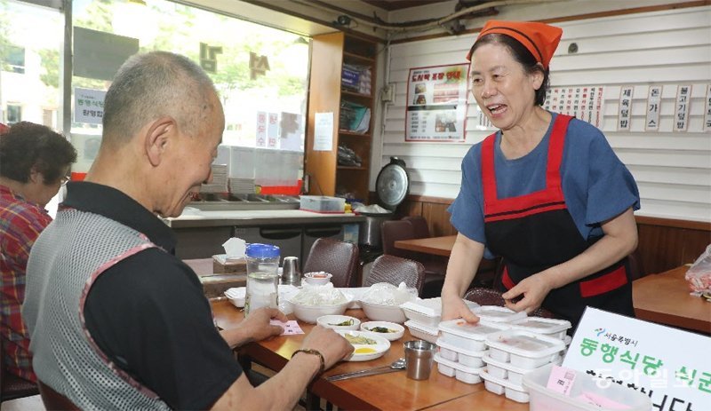 ‘동행식당’으로 지정된 김밥천국 서울역점 점주 구공례 씨(오른쪽)가 가게를 찾은 쪽방촌 주민들과 대화하고 있다. 서울시는 지난해 
8월부터 쪽방촌 인근 식당 44곳을 ‘동행식당’으로 지정해 주민들이 하루 한 끼 8000원 상당의 식사를 할 수 있도록 지원하고 
있다. 김동주 기자 zoo@donga.com