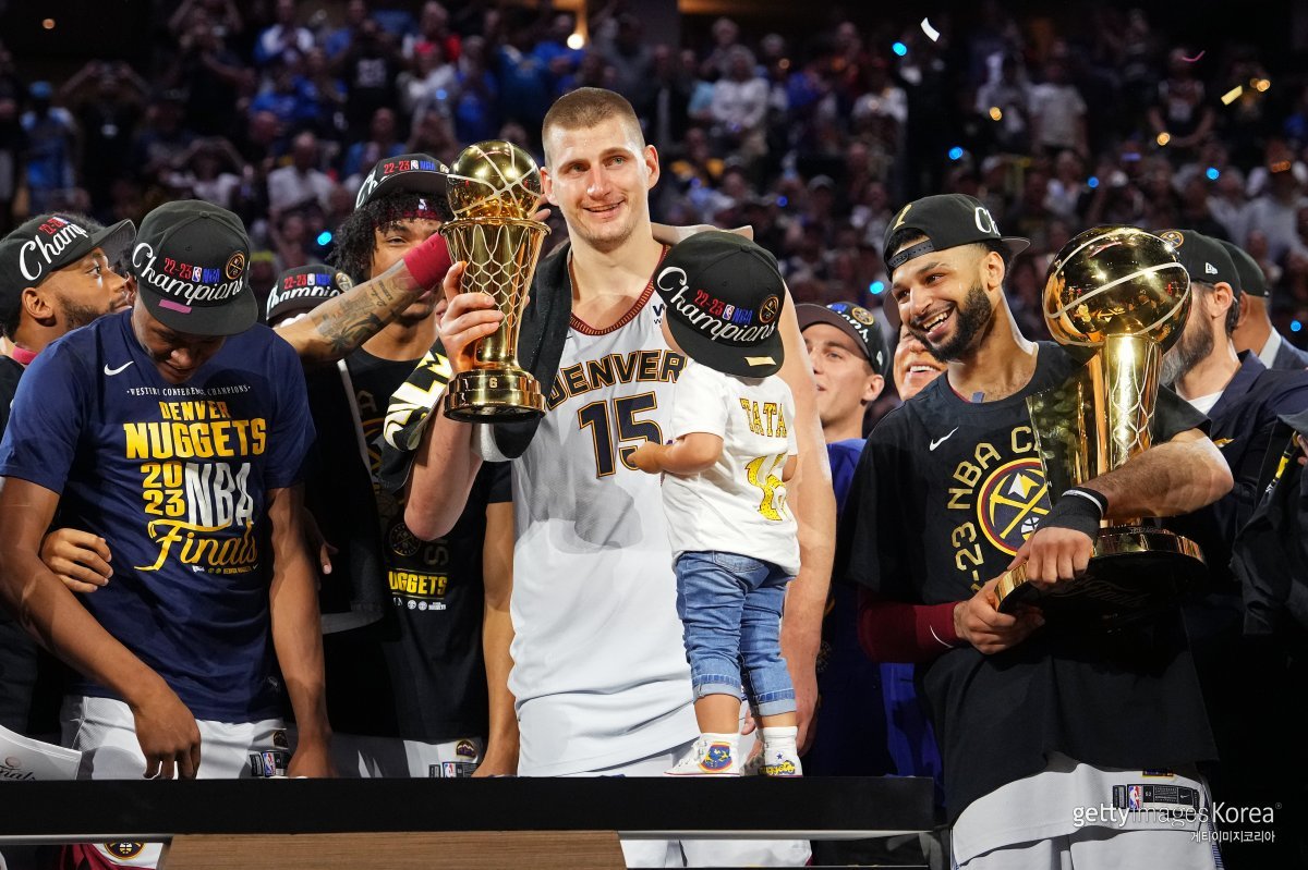 미국프로농구(NBA) 파이널 최우수선수(MVP)로 선정된 덴버의 니콜라 요키치(가운데 15번)가 ‘빌 러셀 트로피’를 받고 있다. 앞에 있는 아이는 요키치의 딸이다. ⓒ(GettyImages)/코리아