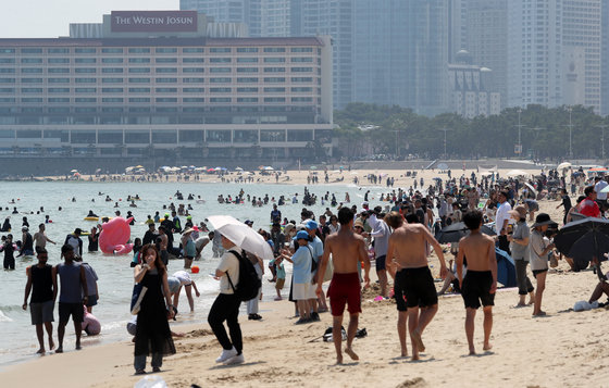 무더위가 기승을 부린 18일 오후 부산 해운대해수욕장을 찾은 피서객들이 물놀이를 즐기며 더위를 식히고 있다. 이날 서울 등 내륙을 중심으로 전국 곳곳에 폭염주의보가 내려졌다. 2023.6.18 뉴스1