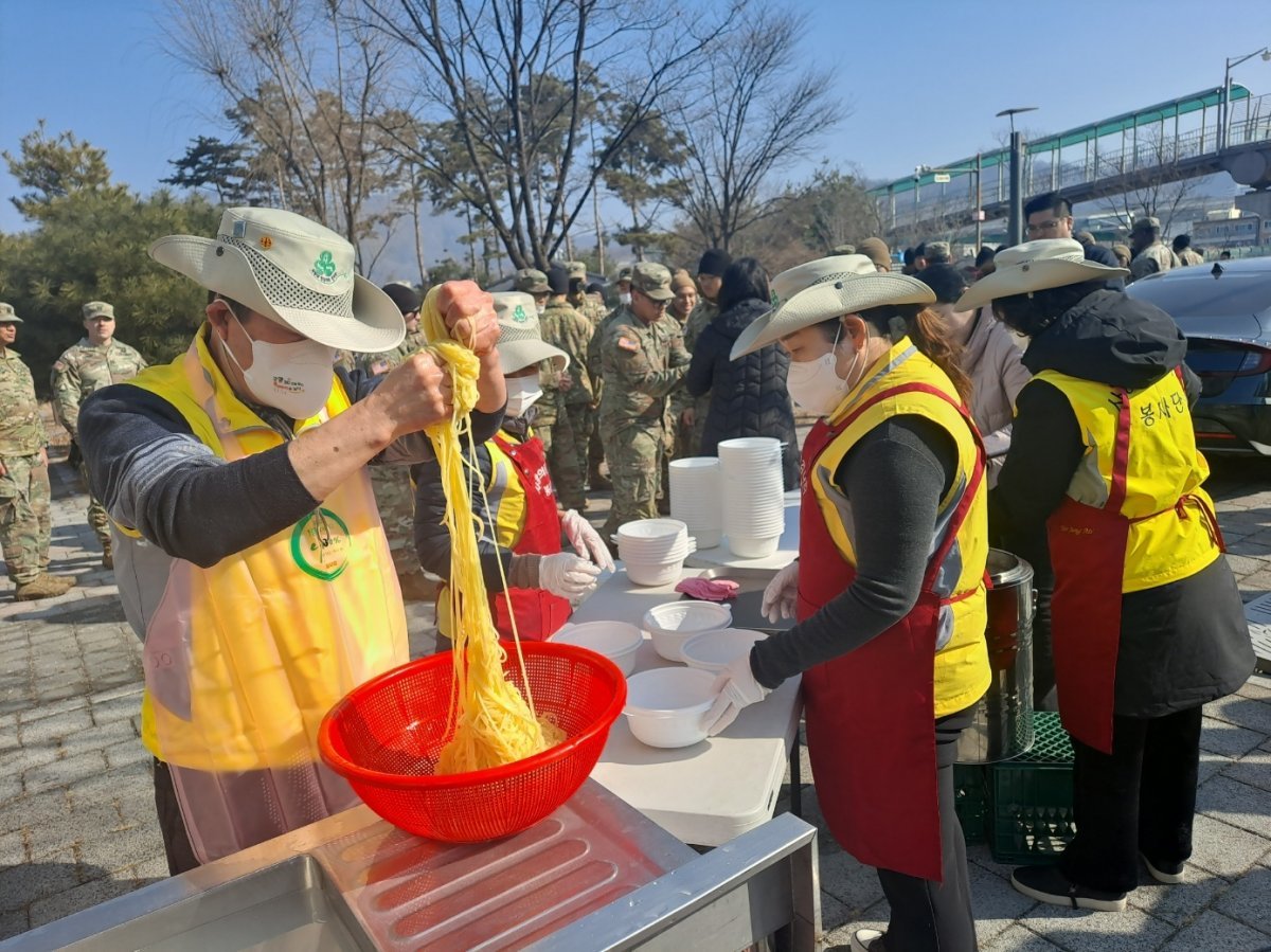 사랑의 징검다리 봉사단이 동두천시에서 미군들과 연탄봉사활동을 하고 미군들에 짜장면 봉사활동을 하는 모습.사진=본인 제공.23.02.08