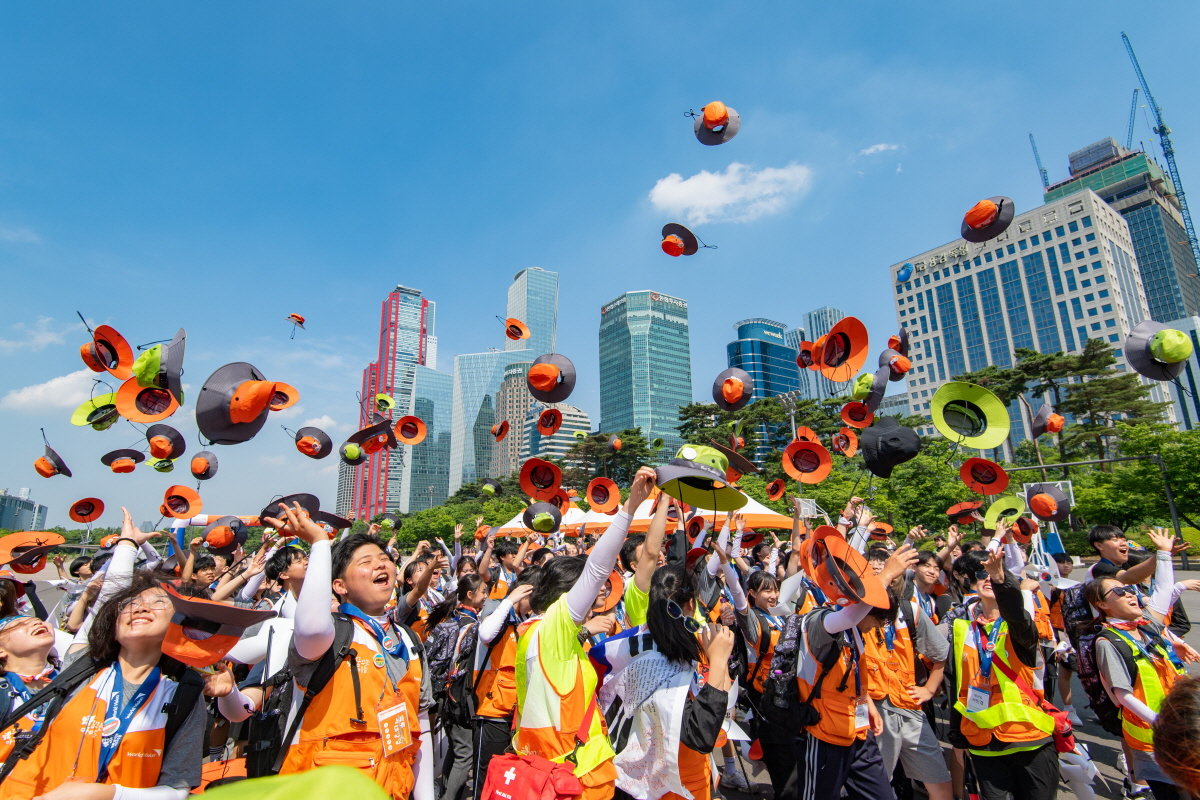 9일 연천∼철원∼서울로 이어지는 60km 코스를 완주한 참가자들이 서울 여의도공원에서 열린 해단식에서 모자를 던지며 환호하고 있다. 월드비전 제공