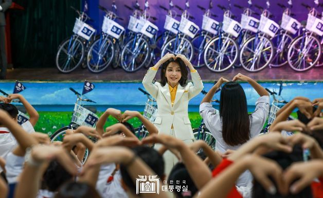 김건희 여사가 22일(현지시간) ‘하노이 SOS 어린이마을 학교’에서 열린 ‘바이크 런(Bike Run)’ 자전거 기부 행사에서 참석자들과 손을 머리 위로 들어 하트를 그려보이고 있다. (대통령실 홈페이지) 2023.6.22/뉴스1