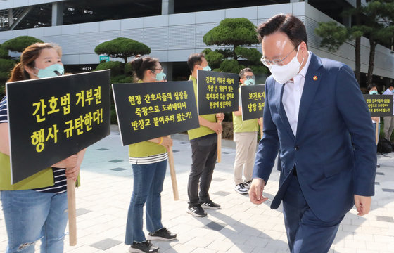 조규홍 보건복지부 장관이 16일 오후 서울 성북구 고려대학교 안암병원에서 열리는 진료지원인력 현장 간담회에 참석하며 윤석열 대통령의 간호법 거부권 행사 규탄 피켓을 든 간호사들 앞을 지나고 있다. 2023.5.16/뉴스1