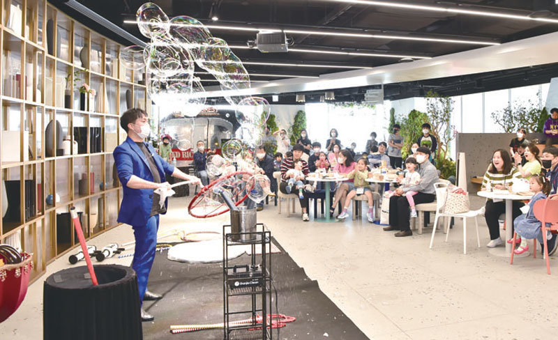 LG에너지솔루션 임직원과 가족들이 본사 엔트럴파크에서 진행된 ‘토토가’ 행사에서 펼쳐지는 마술 공연을 관람하고 있다.