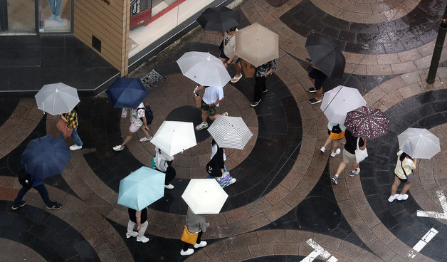 본격적인 장마가 시작된 지난 26일 서울 중구 명동에서 시민들과 외국인 관광객들이 우산을 쓰고 발걸음을 재촉하고 있다. 2023.6.26. 뉴스1