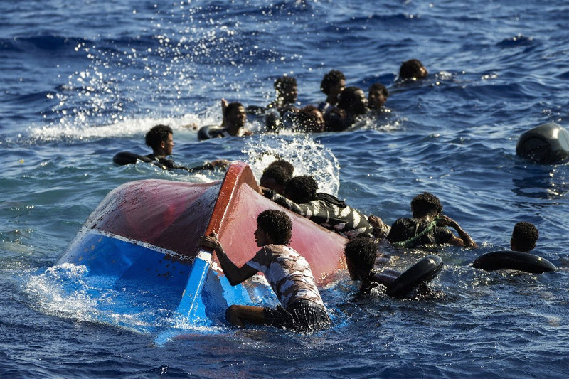 지난해 8월 이탈리아 최남단 람페두사섬 앞바다에서 밀입국선을 타고 온 이주민들이 뒤집힌 배 주변에서 헤엄을 치며 구조를 기다리고 있다. AP 뉴시스