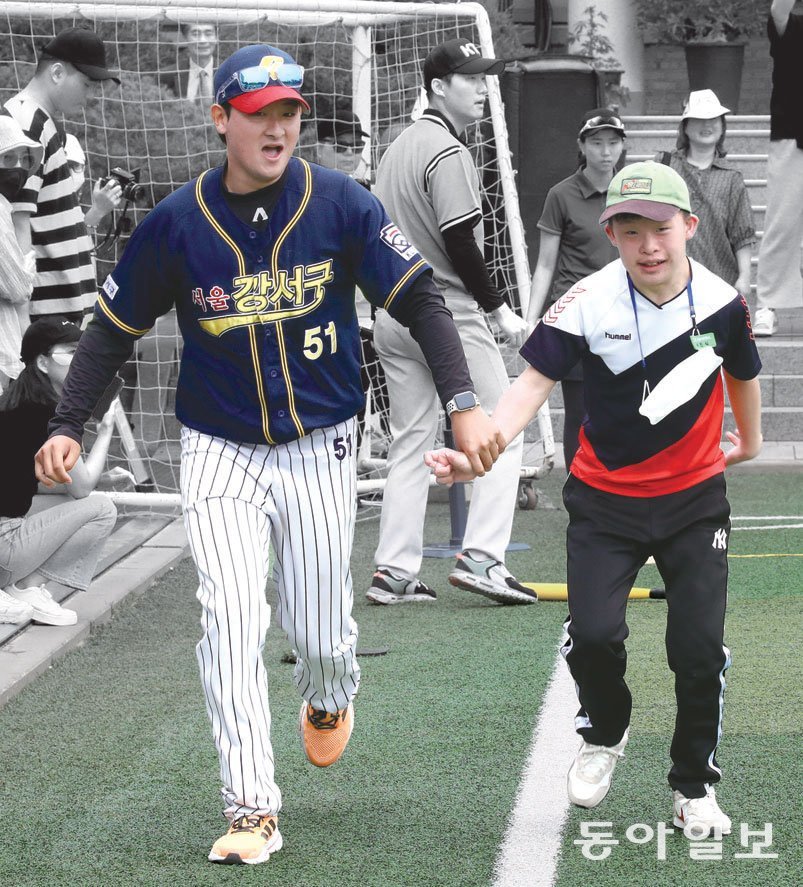 서울서진학교의 한 선수가 공을 친 뒤 봉사자의 도움을 받으며 1루를 향해 힘차게 뛰어가고 있다.
