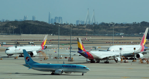 19일 오후 인천국제공항 전망대에서 바라본 계류장에서 대한항공 항공기가 아시아나항공 항공기 앞을 지나고 있다. 2023.2.19/뉴스1