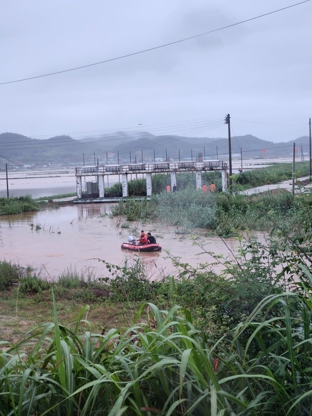 지난 28일 오전 소방대원들이 전남 함평에서 전날 폭우로 불어난 하천 수문을 열다가 실종된 수문 관리자 여성을 찾기 위한 수색 작업을 하고 있다. (독자 제공) 뉴스1