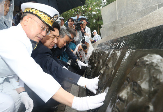 김기현 국민의힘 대표가 29일 오전 경기 평택시 해군 제2함대사령부에서 열린 ‘제2연평해전 승전 21주년 기념식’에서 유가족이 해전 영웅들의 얼굴 부조상을 어루만지고 있다. 2023.6.29 뉴스1