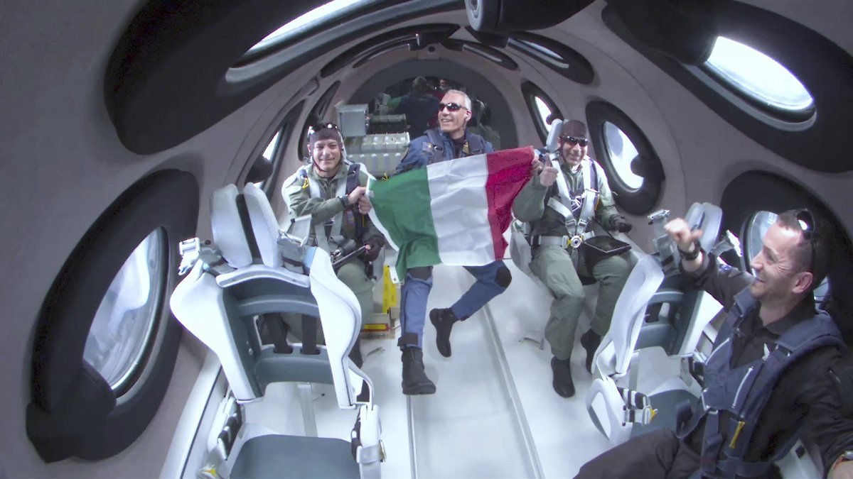 지난달 29일(현지 시간) 영국 ‘버진갤럭틱’의 우주비행선에 탑승한 이탈리아 공군 장교(왼쪽에서 두 번째)가 허공에 둥둥 뜬 상태에서 이탈리아 국기를 펼쳐 들었다. 버진갤럭틱 제공