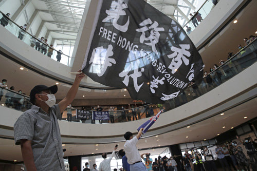 중국의 홍콩 국가보안법 제정에 반대하는 홍콩 시위대가 29일 한 쇼핑몰에서 ‘광복홍콩 시대혁명’이라는 구호가 쓰인 깃발을 흔들고 있다. 2020.5.30 AP 뉴시스