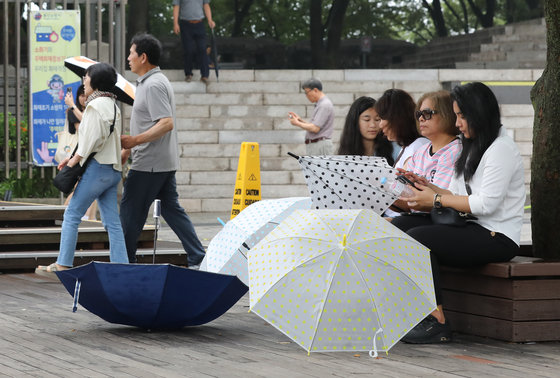 서울지역 장맛비가 소강상태에 접어든 지난 6월30일 서울 중구 남산을 찾은 관광객들이 우산을 땅에 내려놓은 채 휴식을 하고 있다. 2023.6.30 뉴스1