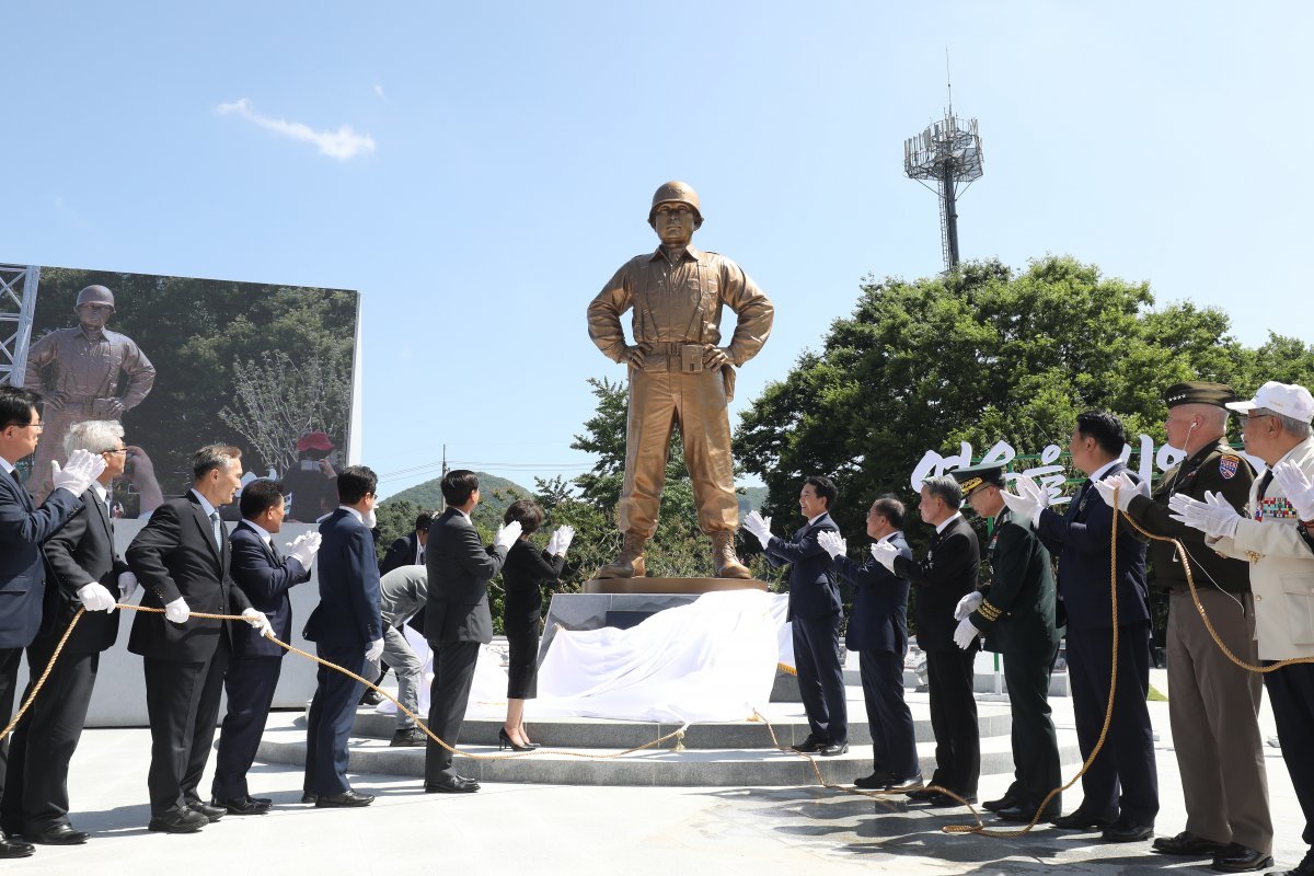 다부동에 세워진 백선엽 장군 동상 5일 오후 경북 칠곡군 다부동전적기념관에서 열린 6·25전쟁 영웅 고 백선엽 장군의 동상 제막식에서 참석자들이 제막을 하고 있다.
 백 장군 동상은 높이 4.2m,너비 1.56m 크기로 동서남북 사방으로 대한민국을 지키고 수호한다는 의미를 담아 360도 회전할
 수 있도록 제작됐다.칠곡=뉴스1