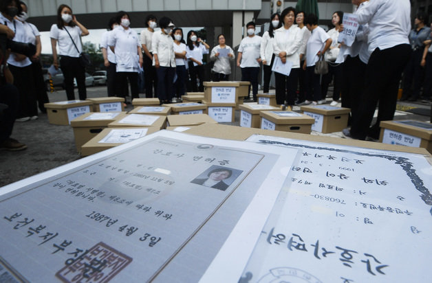 대한간호협회 간호사들이 26일 오전 세종시 어진동 보건복지부를 항의 방문하여 보건복지부의 간호법 허위사실 유포, 불법진료 묵인 등을 규탄하며 간호사면허증을 보건복지부에 반납하기 위해 관계자들과 대치하고 있다. 2023.6.26. 뉴스1