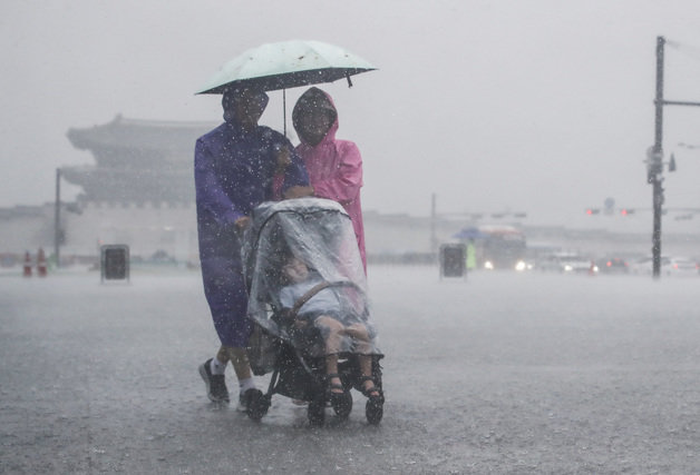 강한 소나기가 내린 9일 서울 종로구 광화문광장에서 한 가족이 우산을 쓰고 발걸음을 서두르고 있다. 2023.7.9/뉴스1