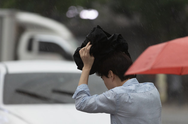 전국 곳곳에 비가 내리는 11일 오전 서울 중구 청계광장에서 우산을 준비하지 못한 한 시민이 발걸음을 재촉하고 있다. 203.7.11 뉴스1
