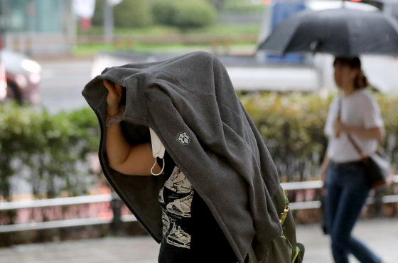 장마전선의 영향으로 많은 비가 예보된 11일 오전 서울 종로에서 우산을 준비 못한 시민이 갑자기 쏟아지는 비를 옷으로 막고 있다. 2023.7.11 뉴스1