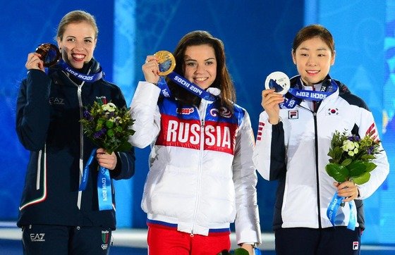 ‘피겨여왕’ 김연아가 22일(한국 시간) 러시아 소치 해안클러스터의 올림픽 파크 내 메달 프라자에서 열린 피겨 여자 싱글 시상식에서 은메달을 목에 걸고 환하게 미소짓고 있다. 1위 아델리나 소트니코바(러시아),2위 김연아(대한민국),3위 카롤리나 코스트너(이탈리아)2014.2.22/뉴스1 DB