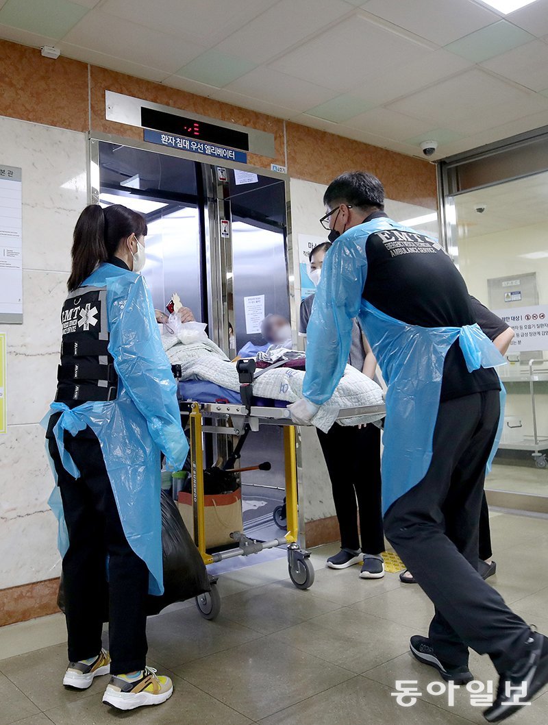 전국보건의료산업노동조합이 13일 총파업을 앞둔 가운데 12일 오후 부산 서구 부산대병원 재활의학과병동 입원실에서 한 환자가 노조 파업으로 진료를 받을 수 없게 되자 민간구급대 직원들에 의해 다른 병원으로 이송하기 위해 입원실 앞 승강기에 오르고 있다. 부산=전영한 기자 scoopjyh@donga.co