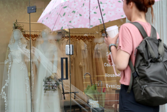 한 시민이 서울 마포구 웨딩타운 드레스 샵 앞에서 웨딩 드레스를 보고 있다.  ⓒ News1