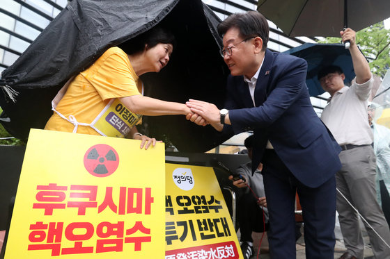 이재명 더불어민주당 대표가 13일 오후 서울 종로구 일본대사관 앞에 마련된 단식농성장을 방문해 후쿠시마 오염수 방류 저지를 위해 18일째 단식 중인 이정미 정의당 대표를 만나 악수를 나누고 있다. 2023.7.13/뉴스1