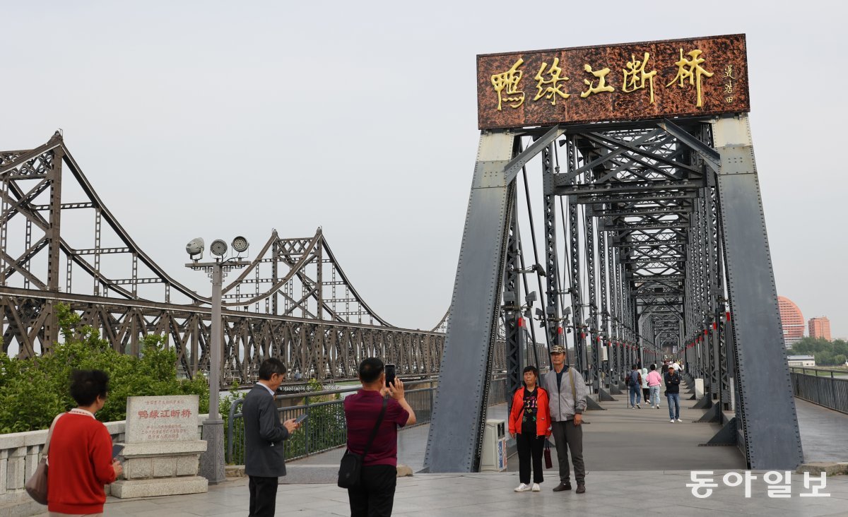 중국 랴오닝성 단둥의  ‘압록강 단교’에서 관광객들이 사진을 찍고 있다.  단교 왼편으로 북중 교역의 주요 통로인  ‘중조우의교’로 불리는 압록강 철교가 보인다. 철로와 도로로 쓰인다. 단둥 = 홍진환 기자