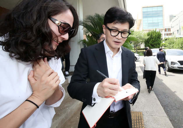 한동훈 법무부 장관이 14일 오전 제주시 연동 광주고등검찰청 산하 제주4·3 직권재심 합동수행단 사무실 앞에서 한 지지자에게 사인을 해 주고 있다.2023.7.14. 뉴스1