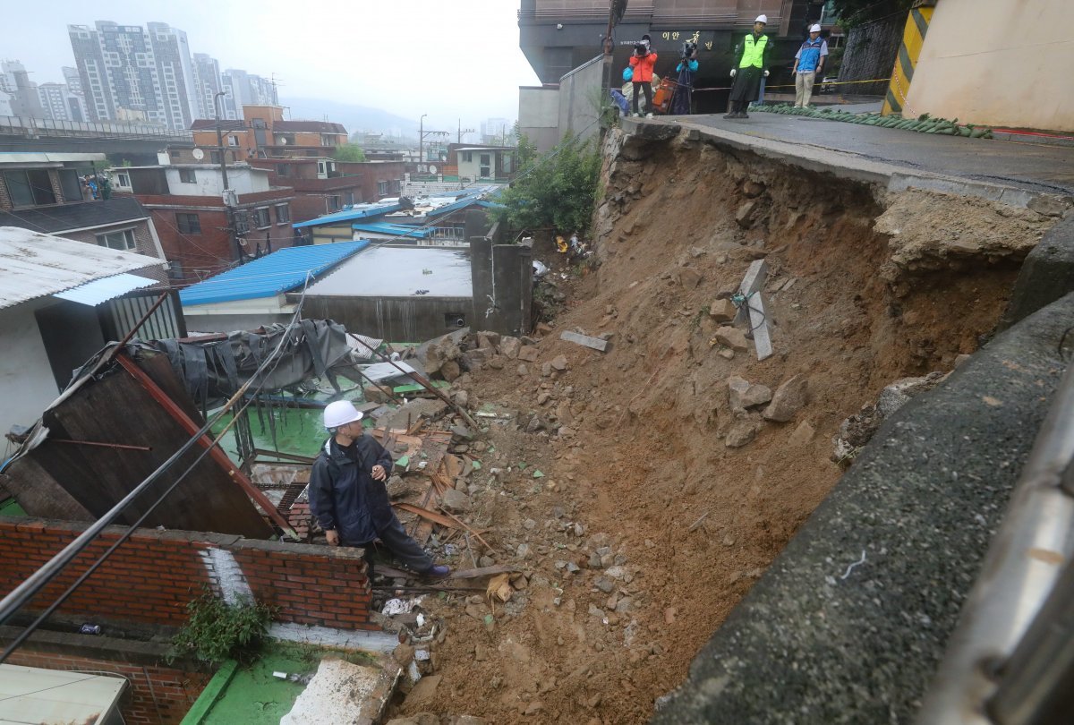 14일 오전 폭우로 축대가 무너진 서울 서대문구 홍제천로의 한 도로에서 서대문구 관계자들이 복구작업을 하고 있다. 뉴시스