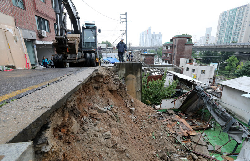 14일 서울 서대문구 연희동에서 구청 관계자들이 지난밤 폭우로 무너진 축대를 복구하고 있다. 이 사고로 인근 20가구 46명이 심야에 긴급 대피했다. 뉴스1