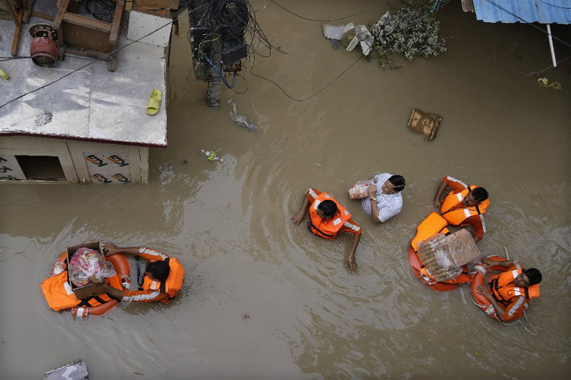 세계 곳곳이 폭염, 폭우 같은 이상기후로 난리다. 인도 수도 뉴델리는 45년 만의 최악 폭우로 13일 자무나강이 범람해 하류 지역 마을이 물에 잠겼다. 국립재난대응단(NDRF) 
소속 요원들이 이재민들에게 구호품을 나눠주고 있다. 지난달 시작된 ‘몬순 우기’로 인도에서는 16일 현재 624명이 숨졌다. 
뉴델리=AP 뉴시스
