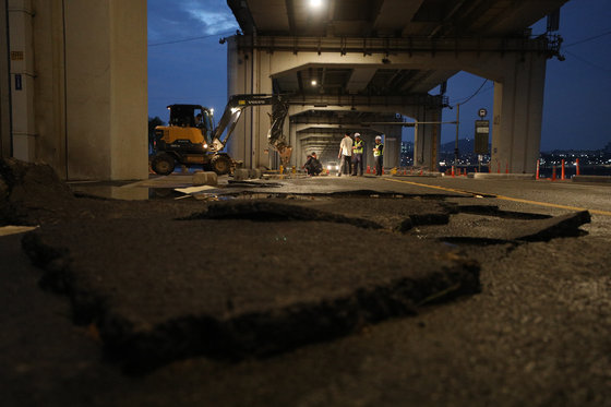 17일 오후 집중 호우로 인한 수위 상승으로 출입이 통제된 서울 잠수교에서 관계자들이 도로 보수를 하고 있다. 2023.7.17/뉴스1